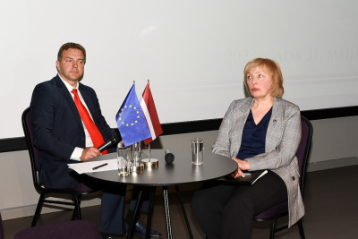 Attēlā attēlots galds ar diskusijas dalībniekiem