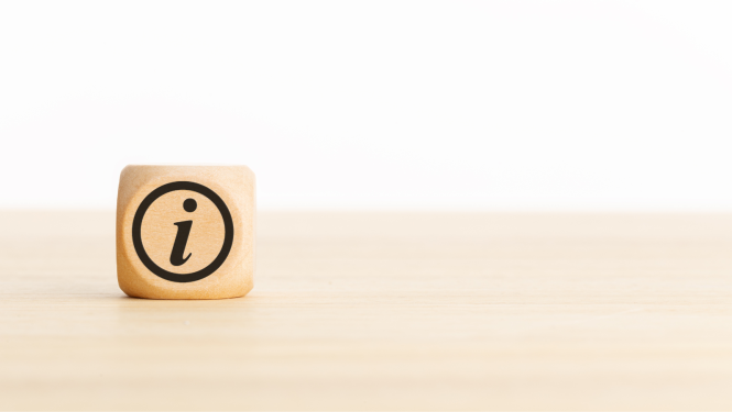 Attēlā redzams koka kubiņš ar melnu "i" burtu aplī.