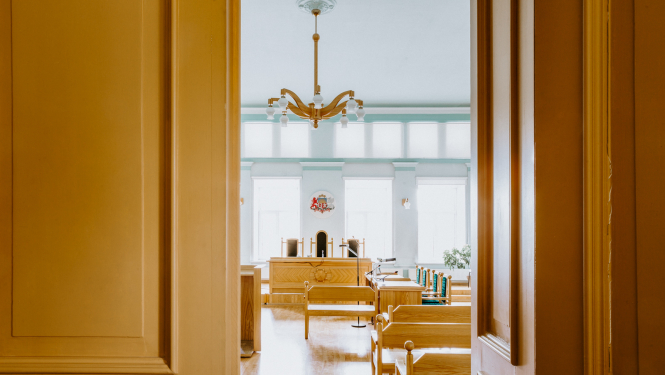 Attēlā redzamas atvērtas durvis, kur tālāk ir tiesas zāle