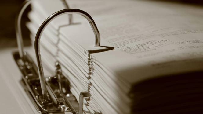 Attēlā redzama bieza mape ar tajā saliktiem dokumentiem