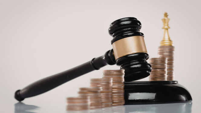 Attēlā redzams tiesneša āmurs un naudas monētu torņi