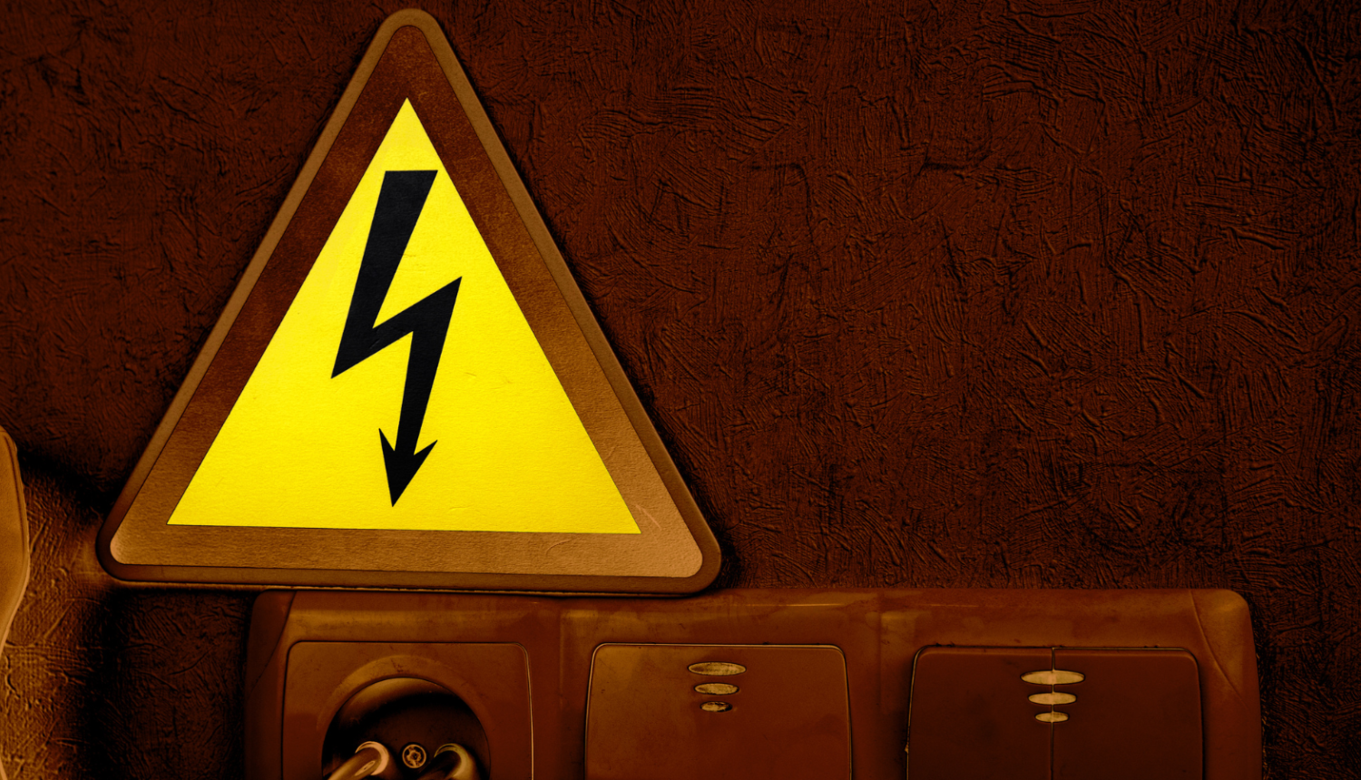 Attēlā redzams dzeltena brīdinājuma zīme, kur iekšā ir zibens zīme, kā brīdinājums