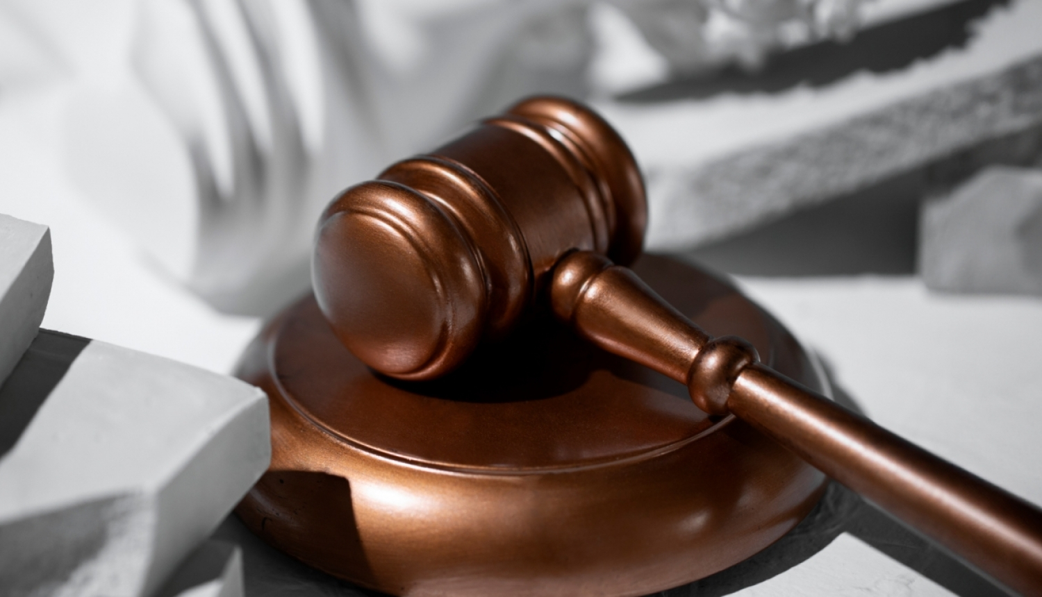 attēlā tiesas āmurs stāv uz galda