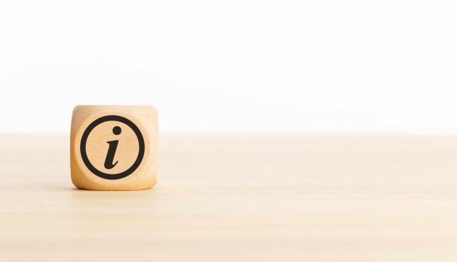 Attēlā redzams koka kubiņš ar melnu "i" burtu aplī.